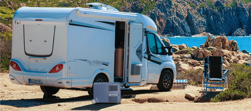 Camper van parked by the sea with a Watergen Mobile Box in its cargo bay